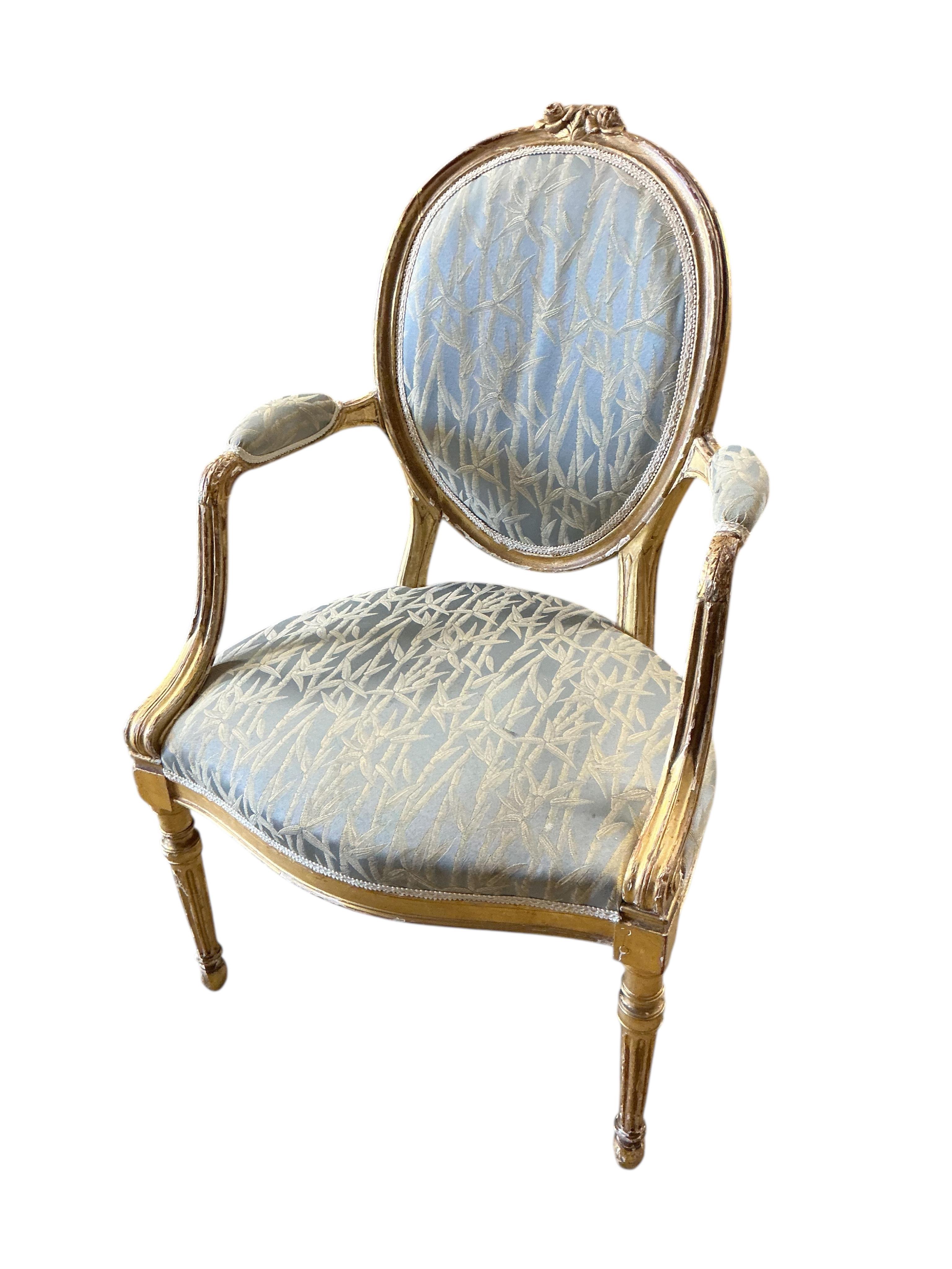 A pair of 18th century carved giltwood open elbow chairs
